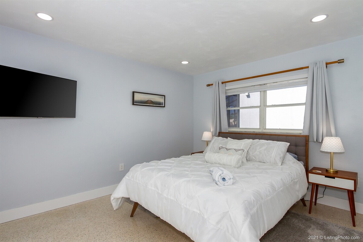 Beheizter Poolbereich mit Lanai, Liegen und Blick auf den Kanal bei Sonnenuntergang.