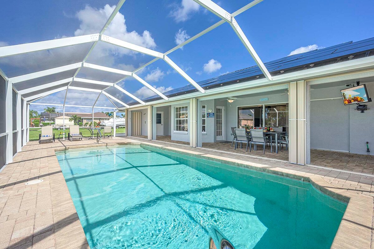 Überdachte Veranda mit Esstisch und Lounge-Bereich am Pool.