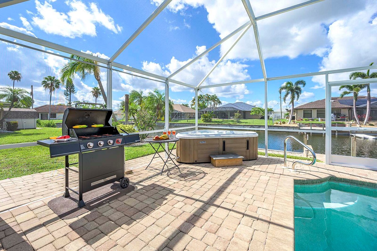 Überdachte Terrasse mit Esstisch und Grillbereich am Pool.