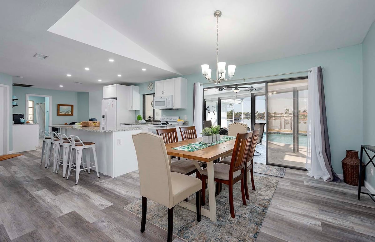 Privater Pool mit Sonnenliegen und Blick auf den See mit Bootsdock.