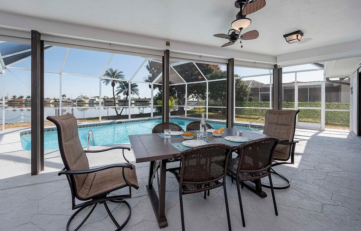 Privater Pool mit Sonnenliegen und überdachter Terrasse am See.