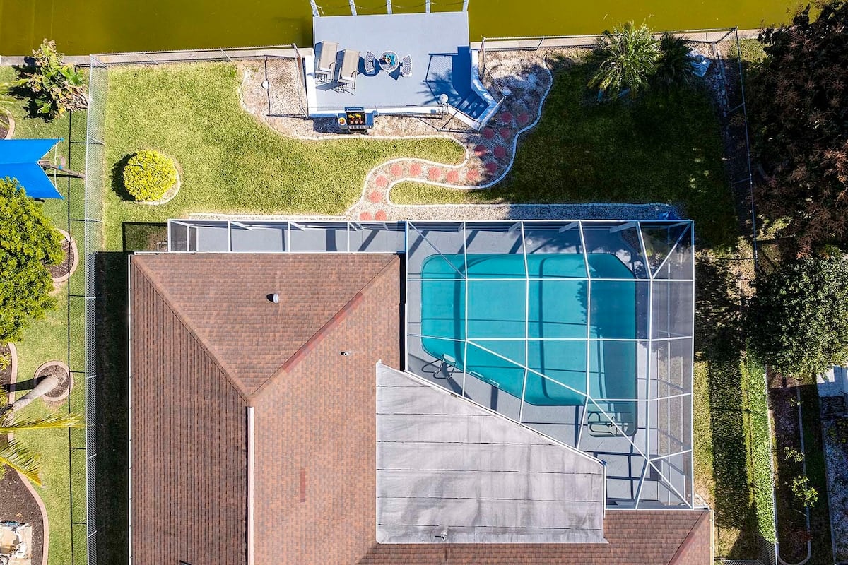 Privater Pool mit Sonnenliegen und Blick auf den See.