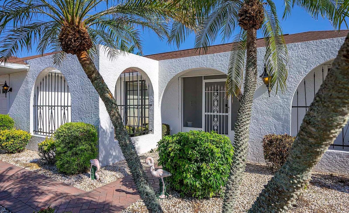 Privater Pool mit Sonnenliegen und Blick auf den See.