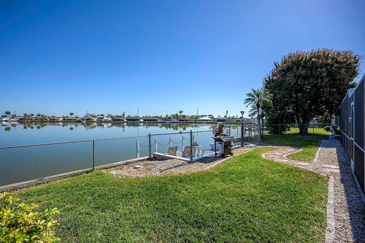 Privater Pool mit Sonnenliegen und Blick auf den See mit Bootsdock.