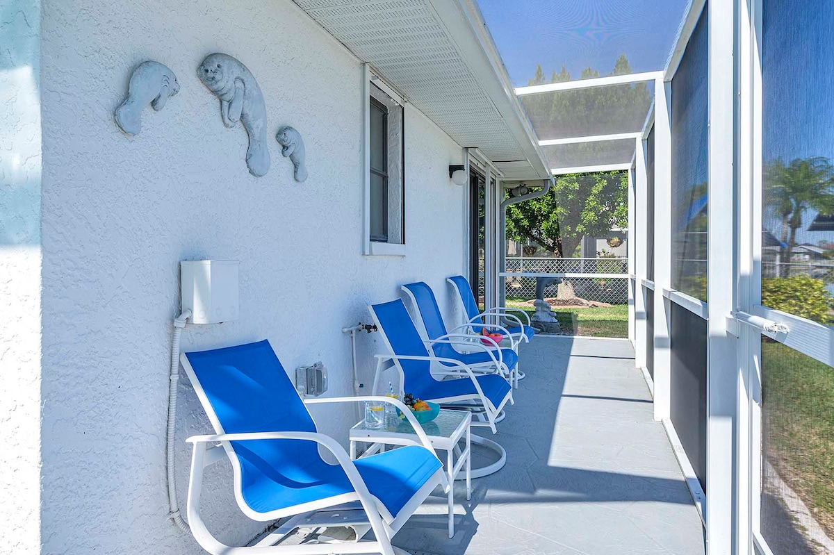Privater Pool mit Sonnenliegen und Blick auf den See mit Bootsdock.