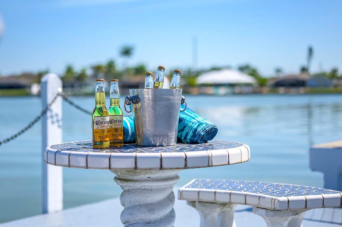 Privater Pool mit Sonnenliegen und Blick auf den See.
