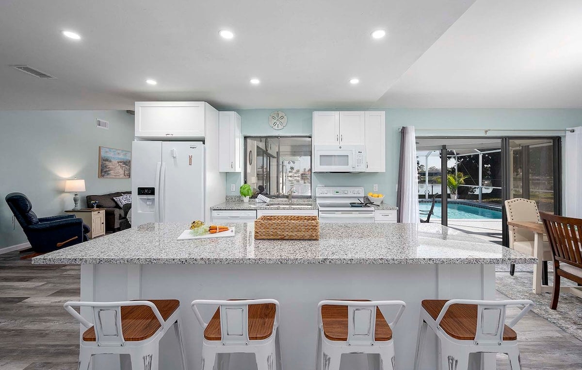 Privater Pool mit Sonnenliegen und Blick auf den See mit Bootsdock.