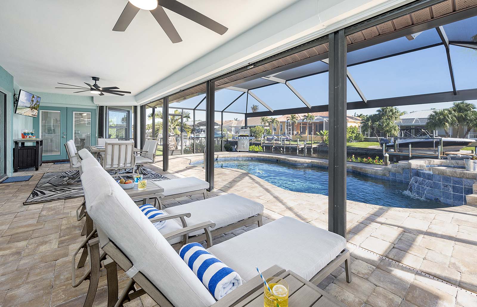 Terrasse am Kanal mit Bootsdock und Sitzbereich.