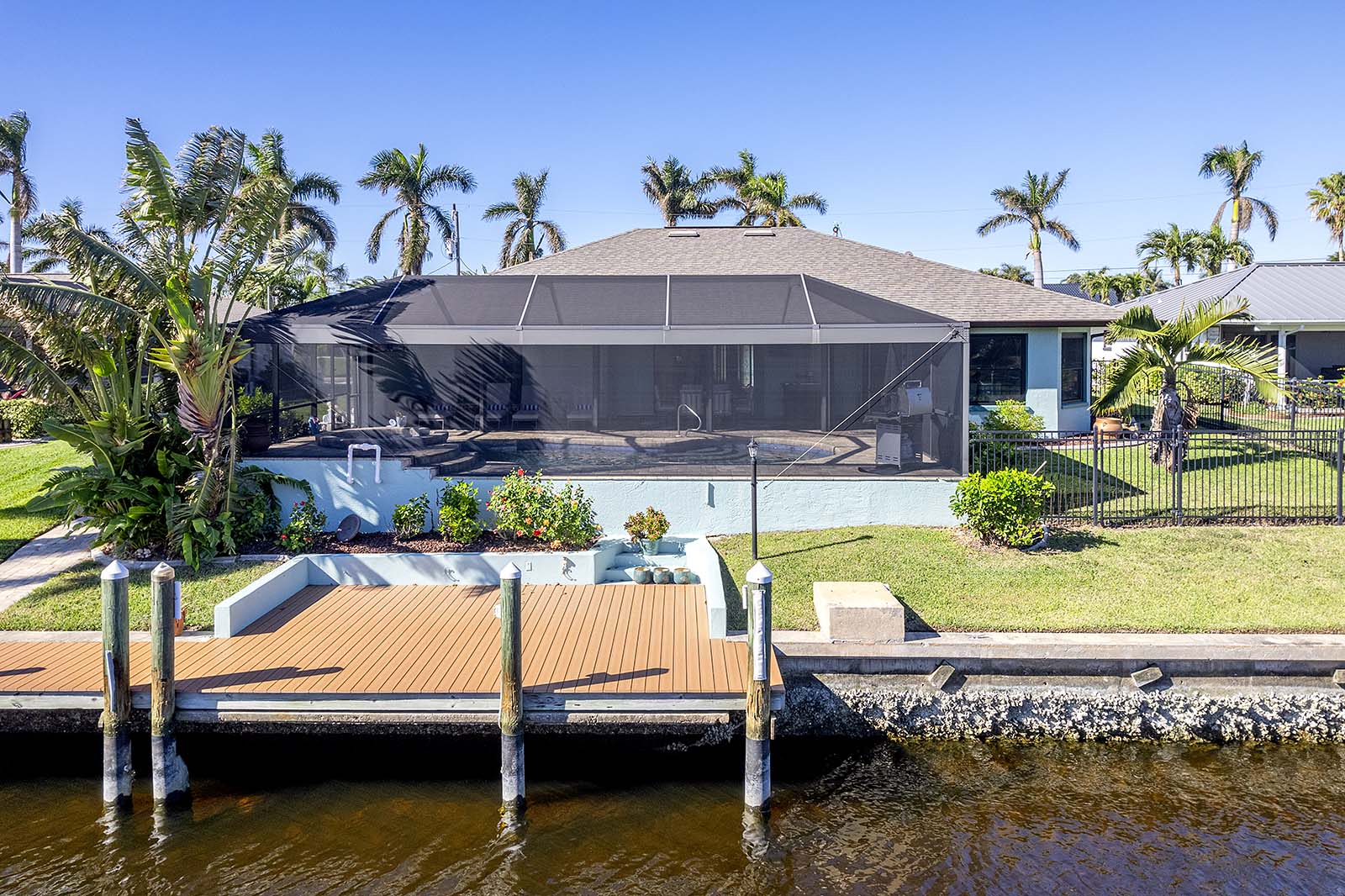 Terrasse am Kanal mit Bootsdock und Sitzbereich.