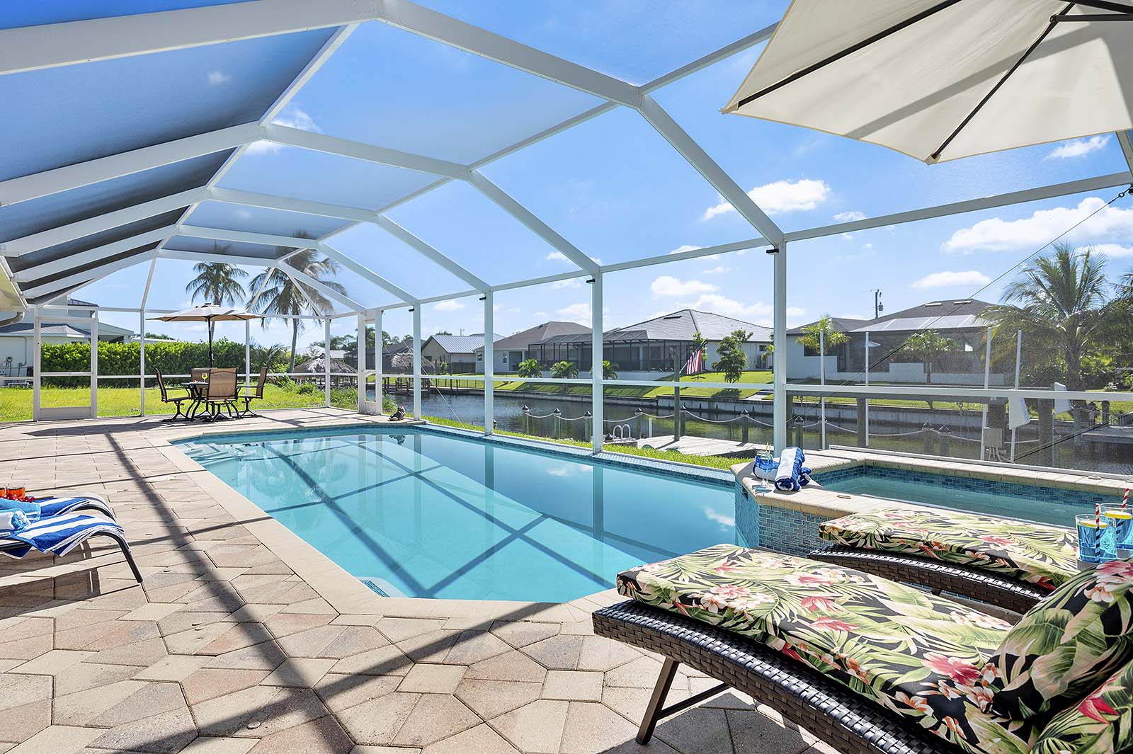 Beheizter Privatpool mit Sonnenliegen und TV im Außenbereich.