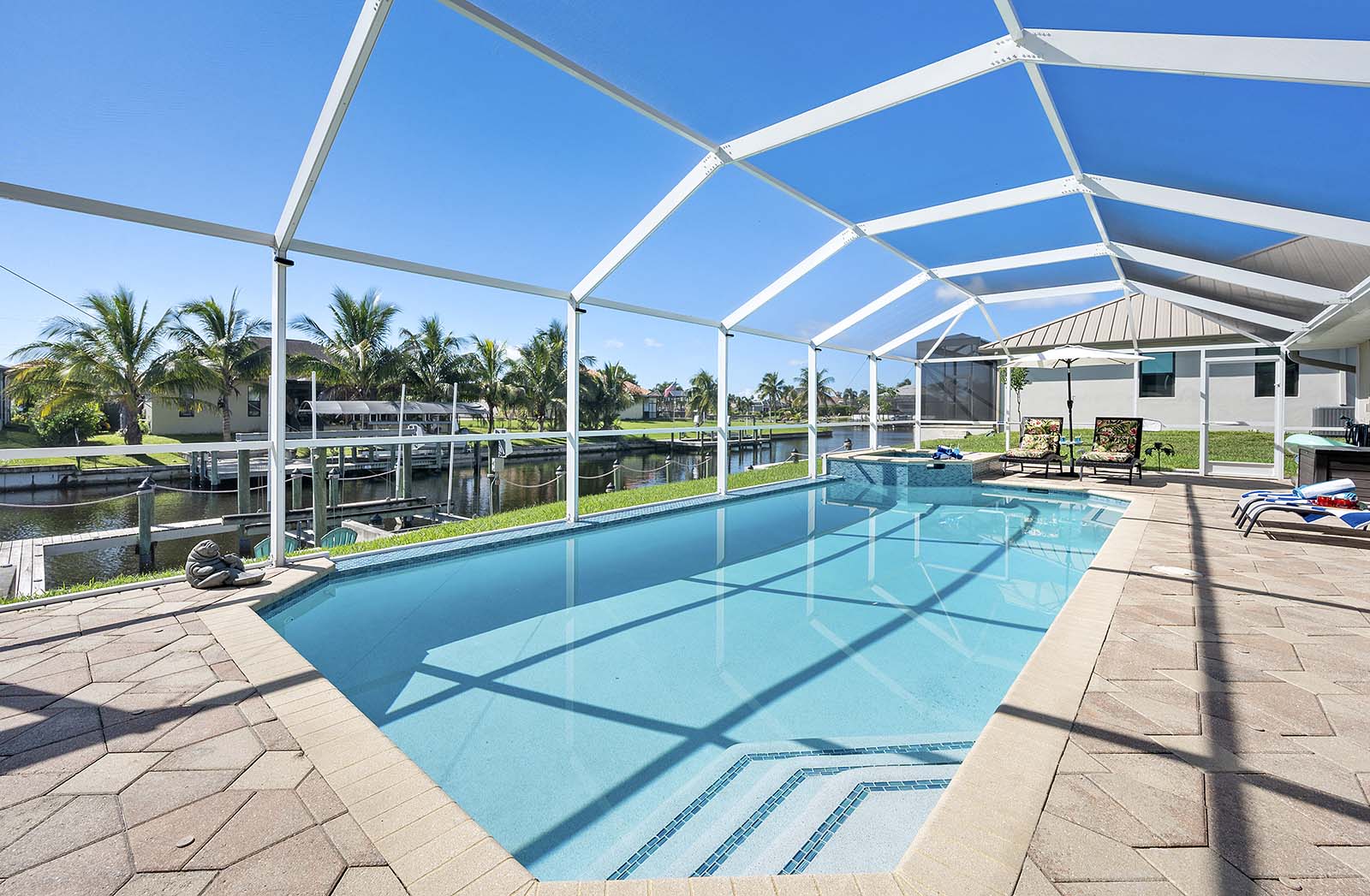 Beheizter Privatpool mit Sonnenliegen und TV im Außenbereich.