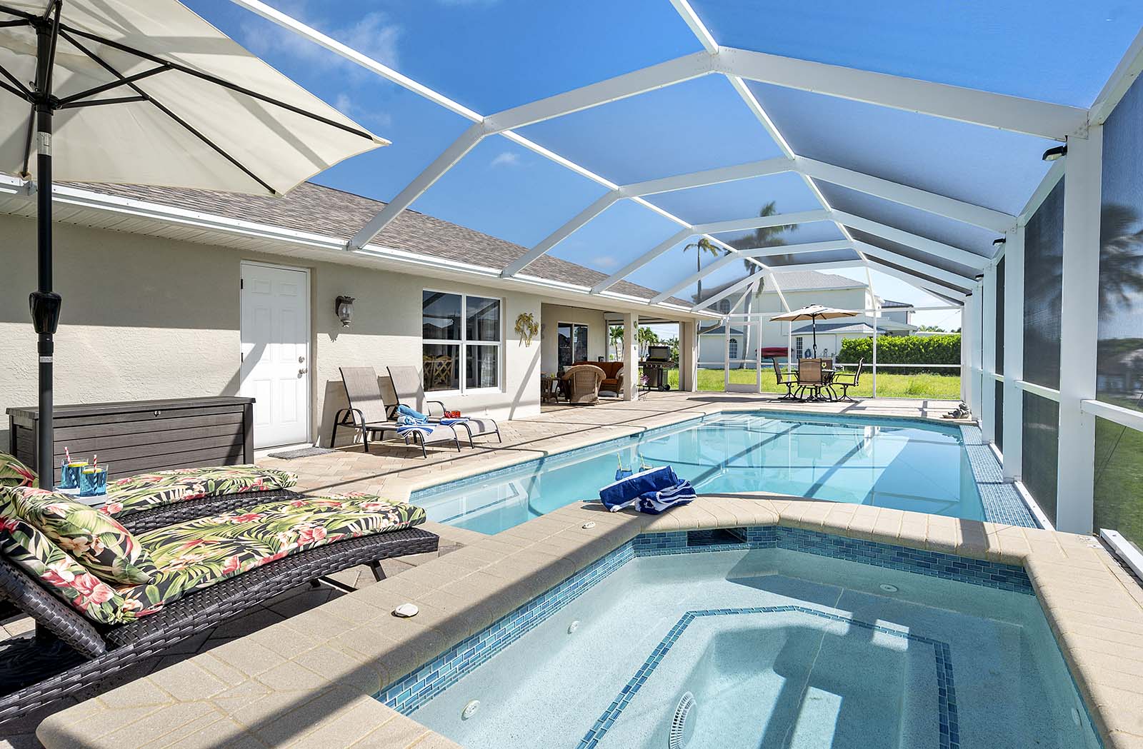 Beheizter Privatpool mit Sonnenliegen und TV im Außenbereich.