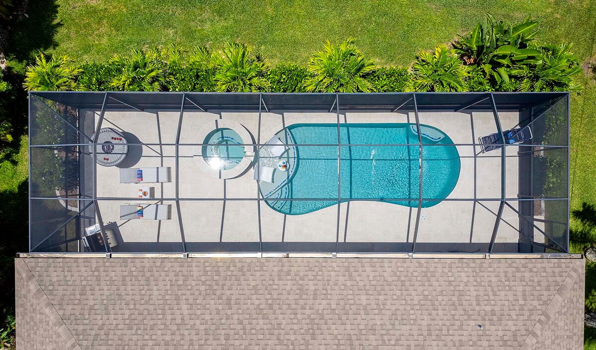 Sonnige Poolterrasse mit Salzwasser-Pool, Outdoor-Küche und Blick auf den Kanal.