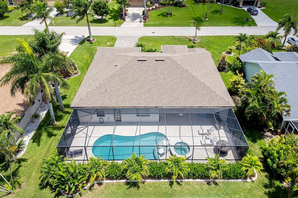 Außenbereich mit Salzwasser-Pool, Liegen und Outdoor-Küche mit Bar am Kanal.