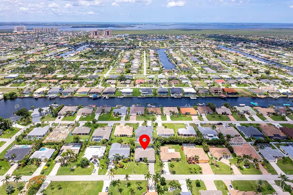 Sonnige Poolterrasse mit Salzwasser-Pool, Liegen und Outdoor-Küche am Kanal.