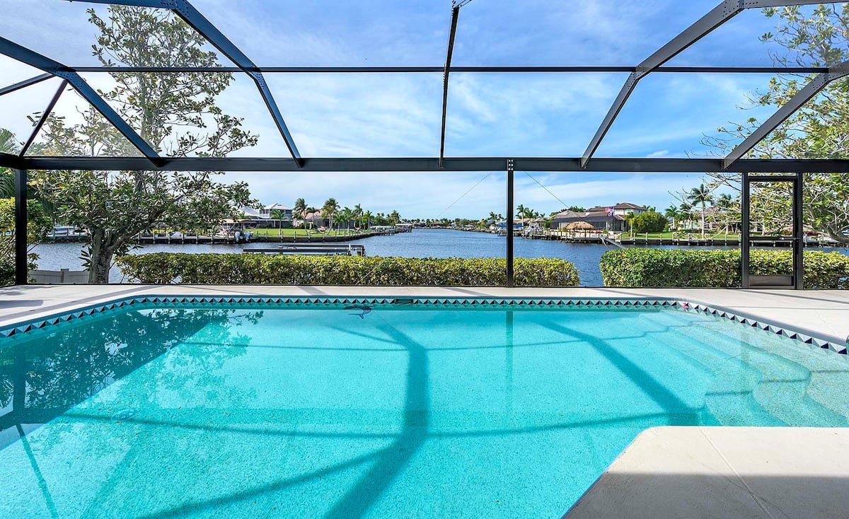 Beheizter Poolbereich mit Sonnenliegen und Blick auf den Kanal.