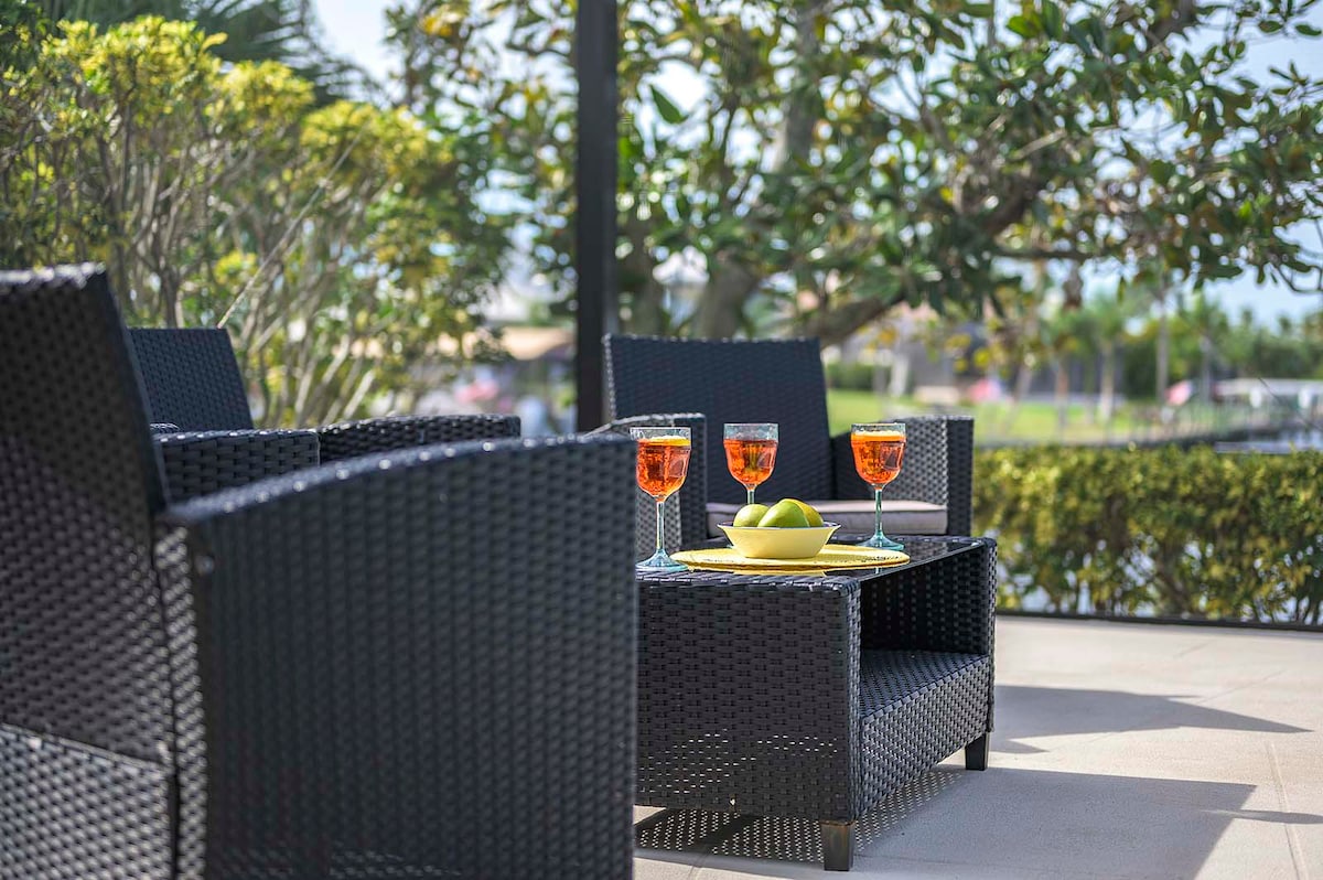 Beheizter Poolbereich mit Sonnenliegen und Blick auf den Kanal.