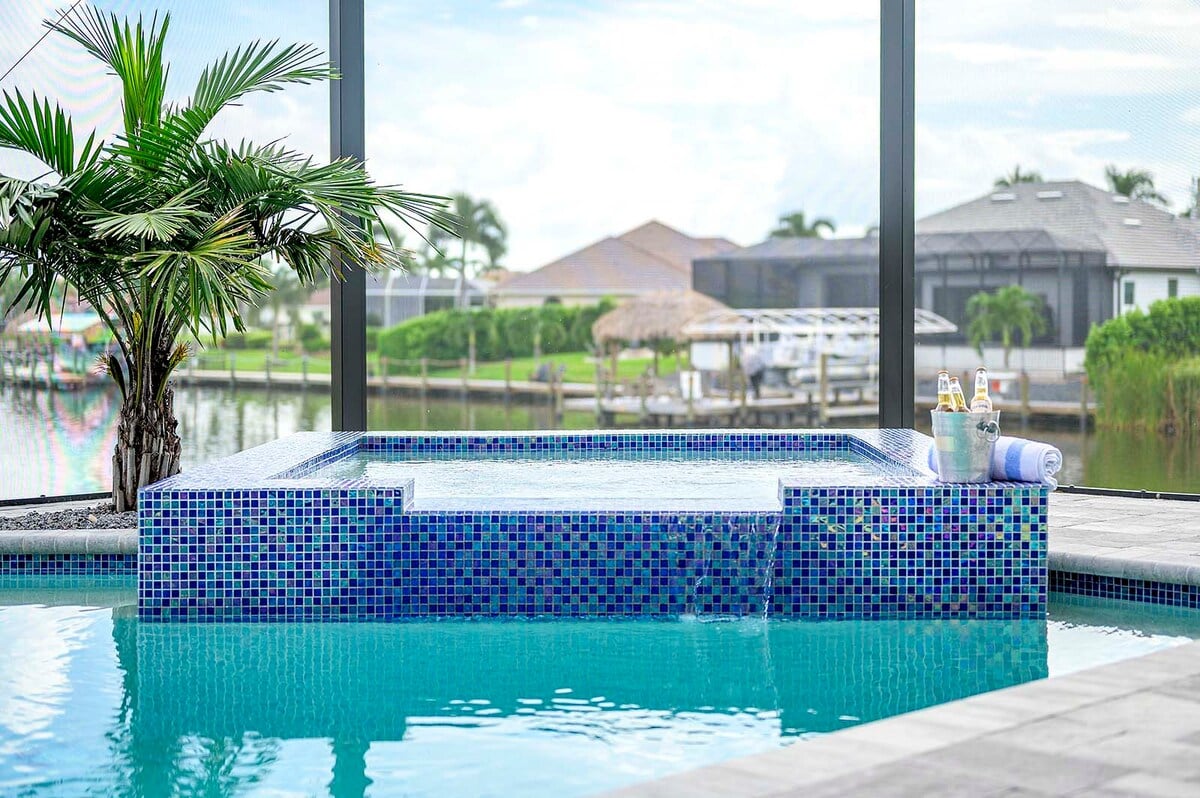 Pool- und Whirlpoolbereich am Kanal mit Bootsanleger.