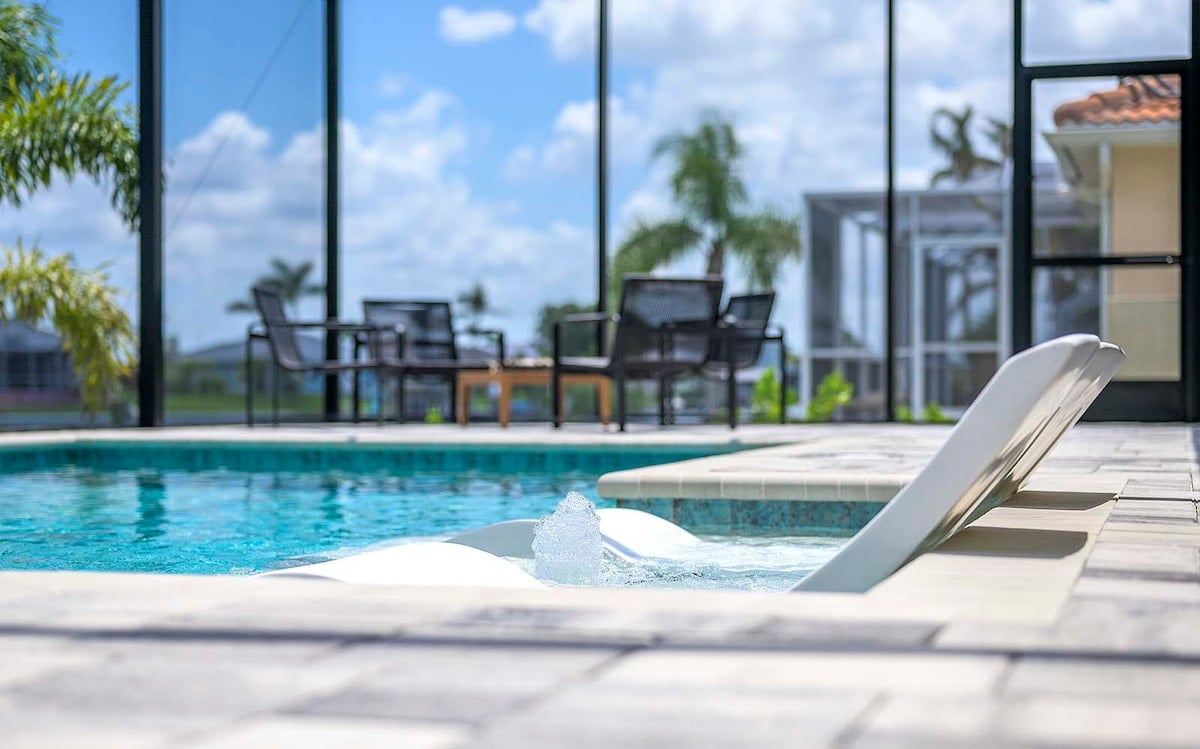 Überdachte Terrasse mit Esstisch und Blick auf den Kanal.