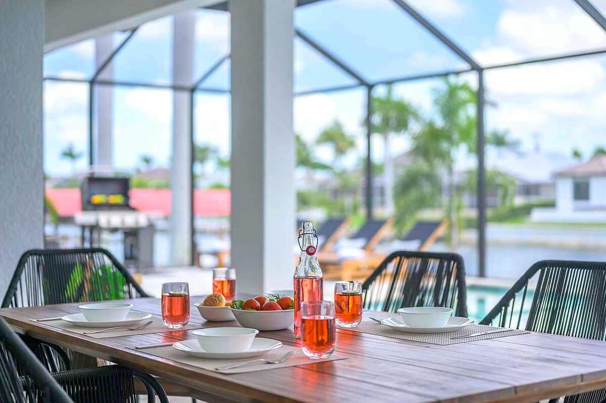 Überdachte Veranda mit Essbereich und Blick auf den Kanal.