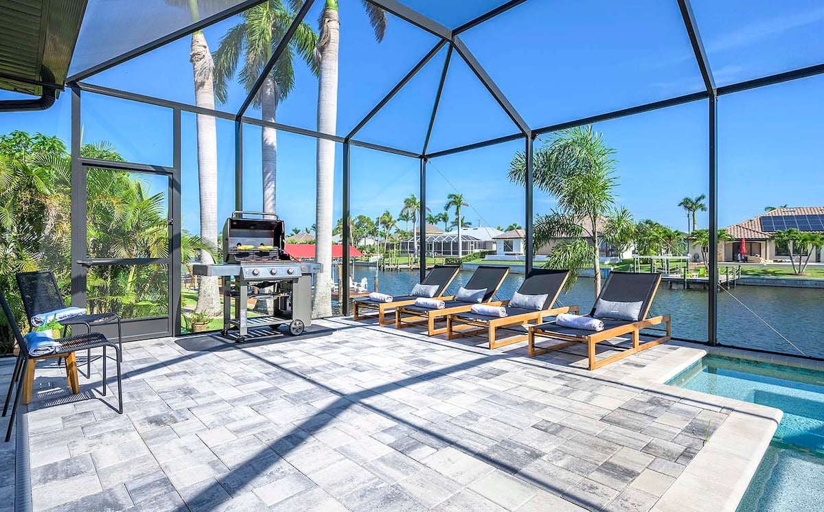 Überdachte Veranda mit Grillbereich und Blick auf den Kanal.