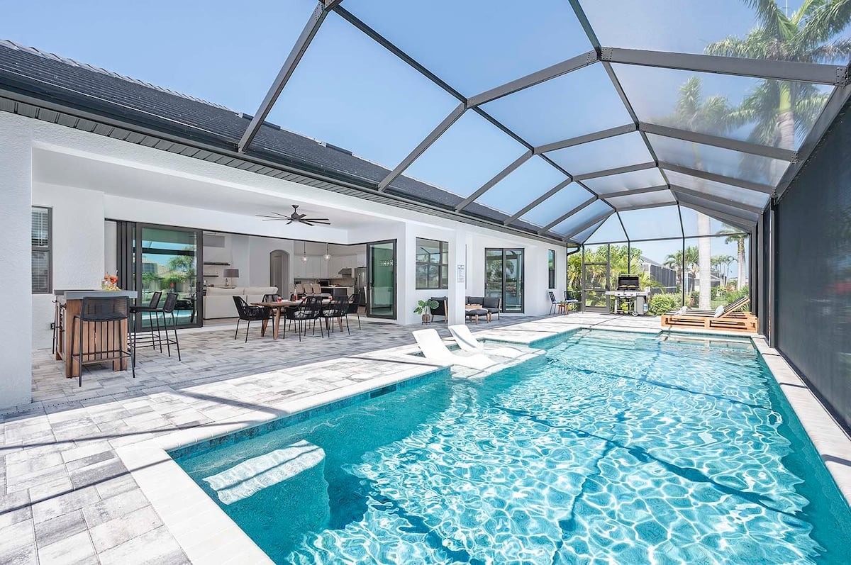 Überdachte Terrasse mit Esstisch und Blick auf den Kanal.