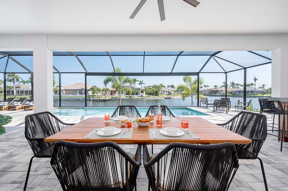 Überdachte Terrasse mit Esstisch und Blick auf den Kanal.