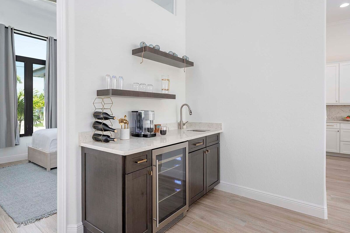 Überdachte Terrasse mit Esstisch und Blick auf Kanal und Pool.