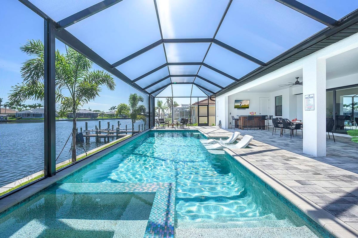 Überdachte Terrasse mit Blick auf den Kanal und den Pool.