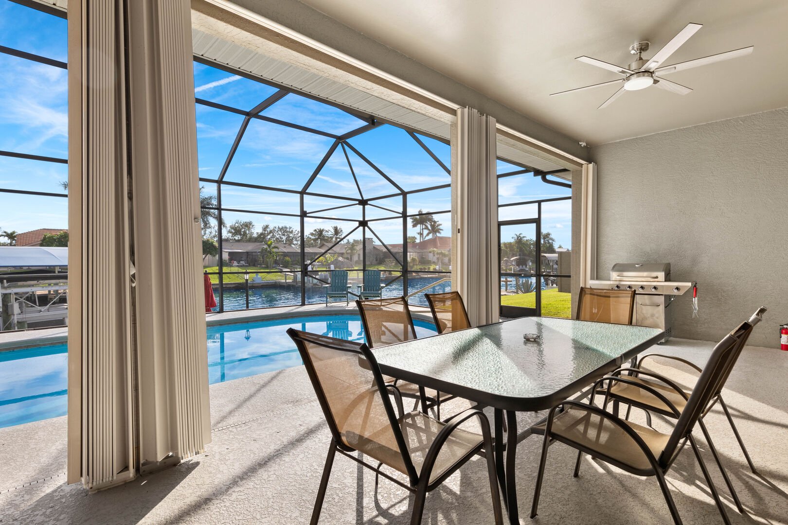 Lanai mit Esstisch, Grill und Blick auf den Kanal.