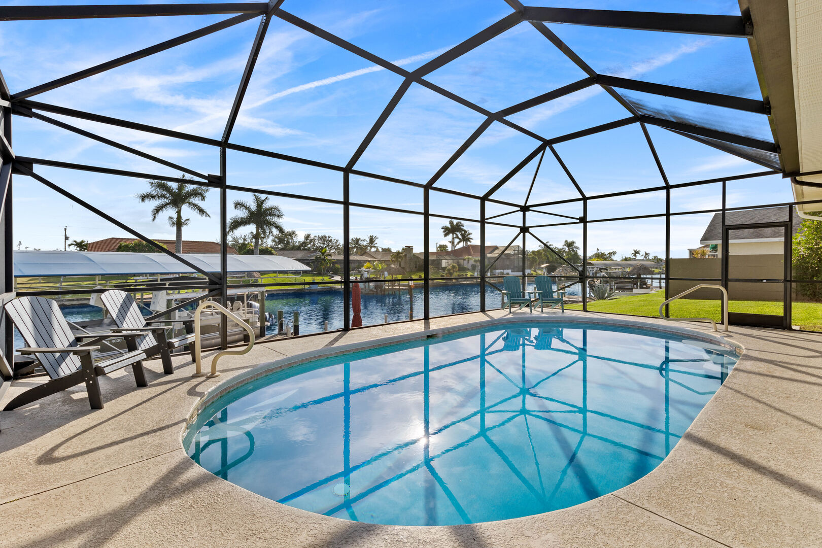 Lanai mit Outdoor-Esstisch, Grill und Blick auf den Kanal.