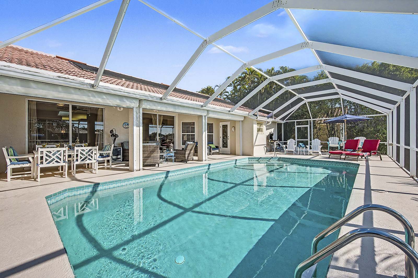 Sonnige Poolterrasse am Kanal mit Bootsdock und Tiki-Hut.