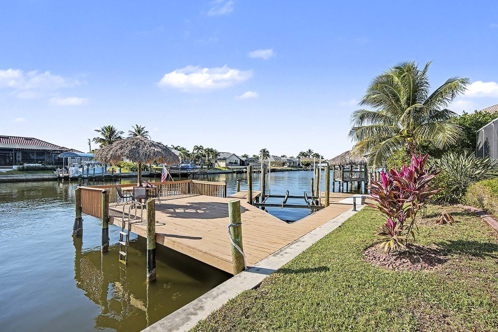 Südseitiger Poolbereich mit Blick auf den Kanal und privatem Bootsdock mit Tiki-Hut.