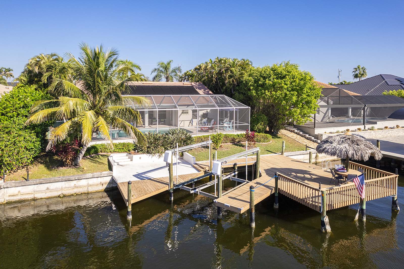 Privates Bootsdock mit Tiki-Hut am Kanal bei Sonnenuntergang.