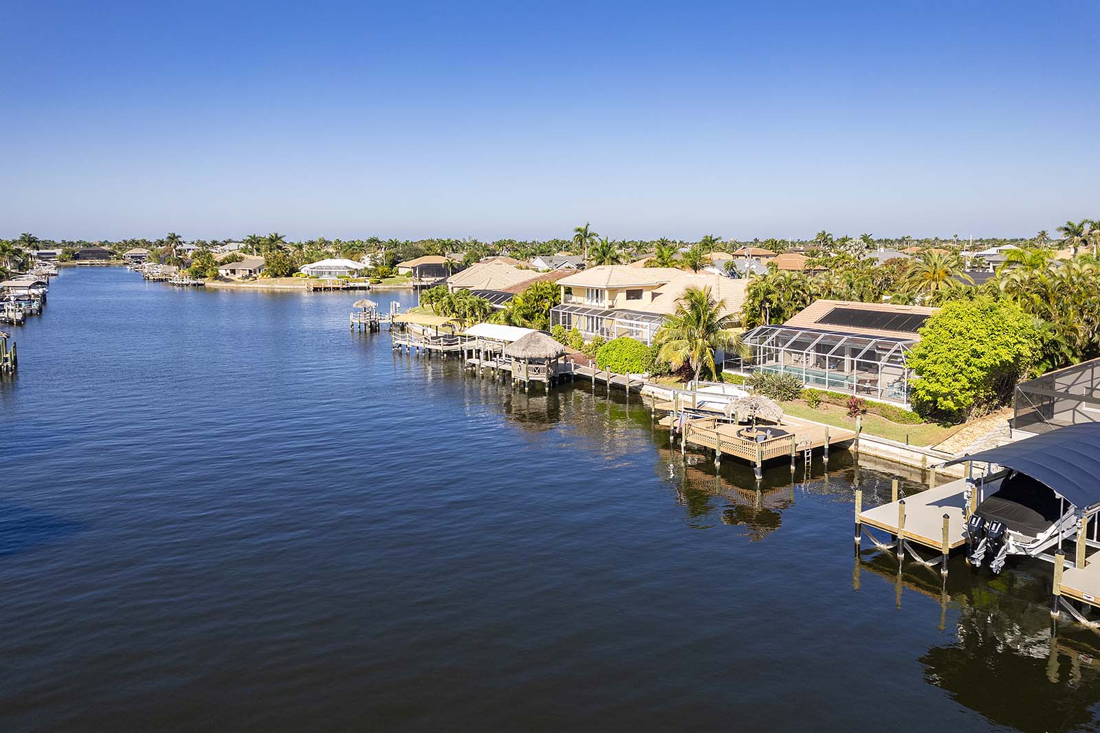 Privates Bootsdock am Kanal mit Tiki Hut und Sitzbereich.