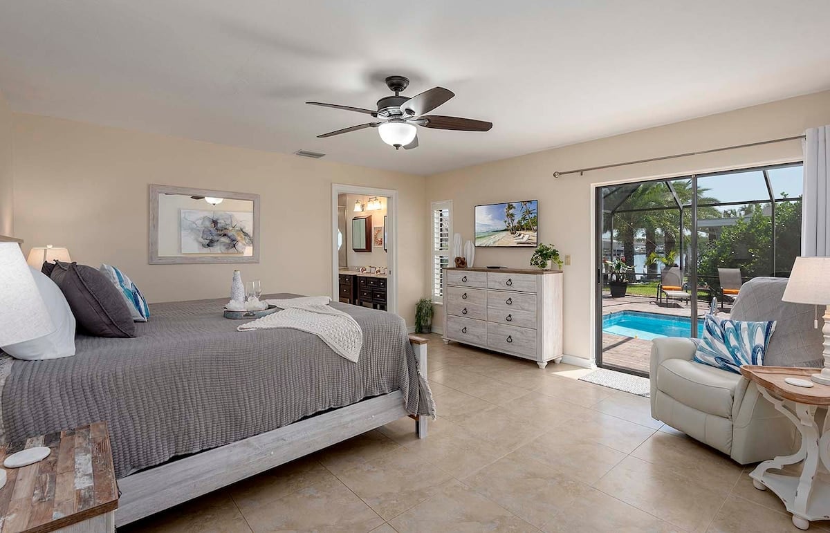 Beheizter Pool mit Lanai und Sitzbereich im Garten.