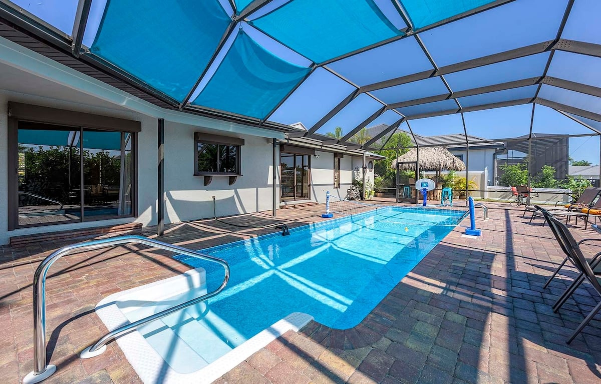 Beheizter Pool auf der Lanai mit Sitzbereich und Blick in den privaten Garten.