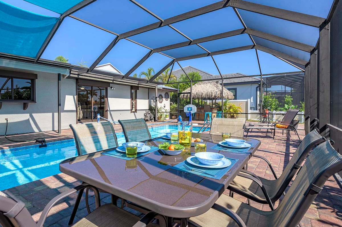 Beheizter Pool mit Lanai und Sitzbereich im Garten.