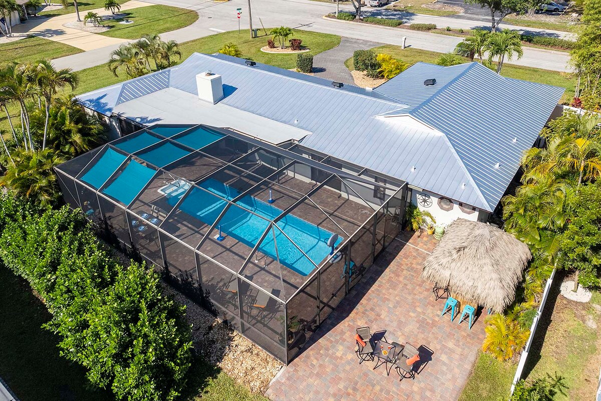 Beheizter Pool mit Lanai und Sitzbereich im Garten.