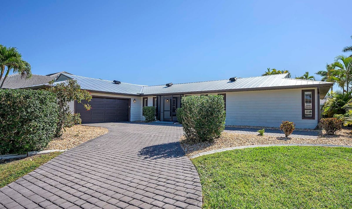 Beheizter Pool mit Lanai und Sitzbereich im Garten.