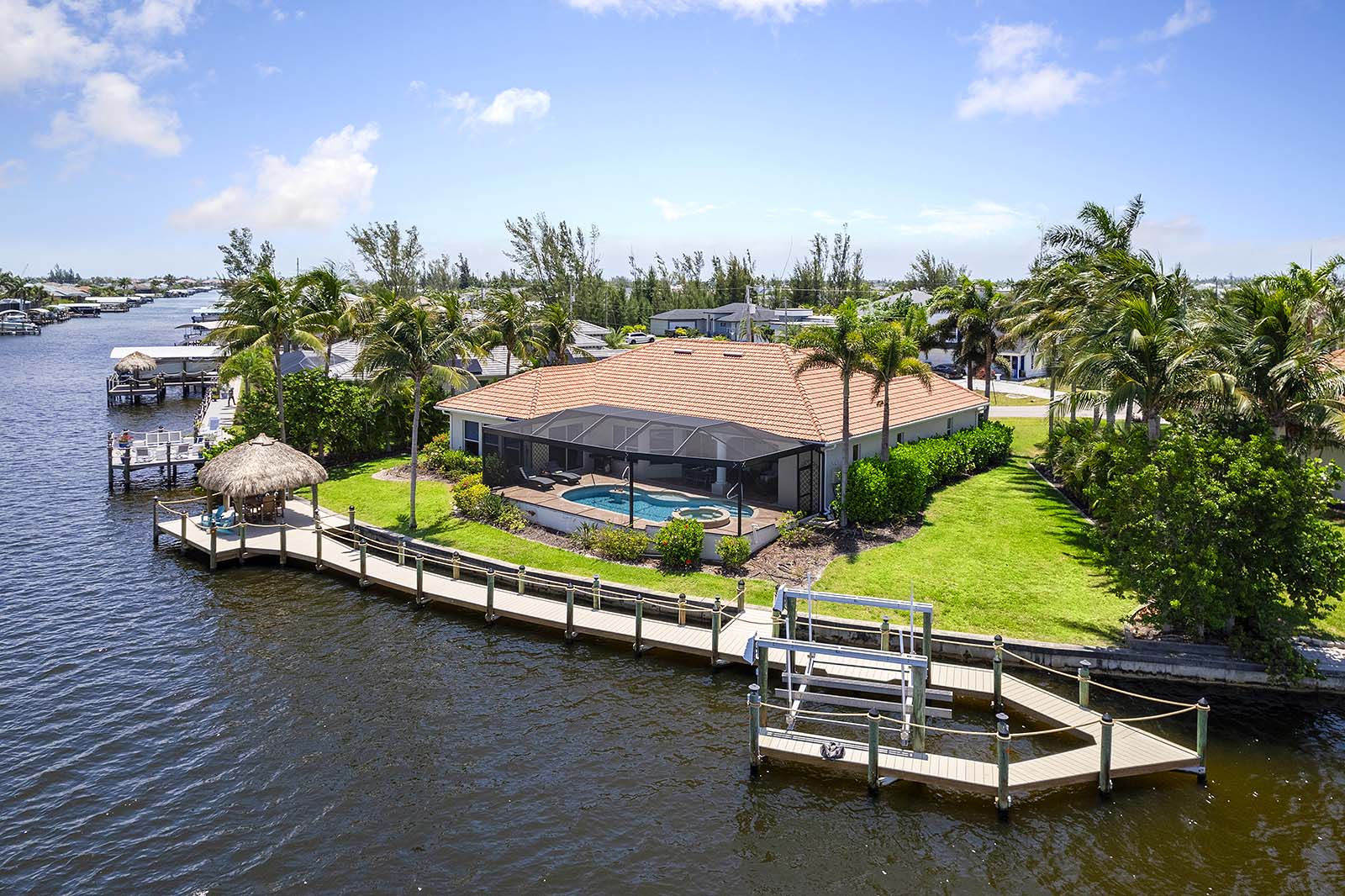 Privates Dock am Kanal mit Bootslift und Blick aufs Wasser.