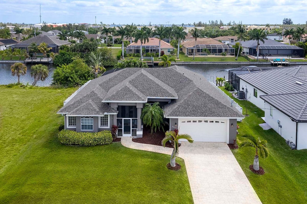 Blick auf den Kanal vom Bootssteg mit Sitzmöglichkeiten und Uferbepflanzung.