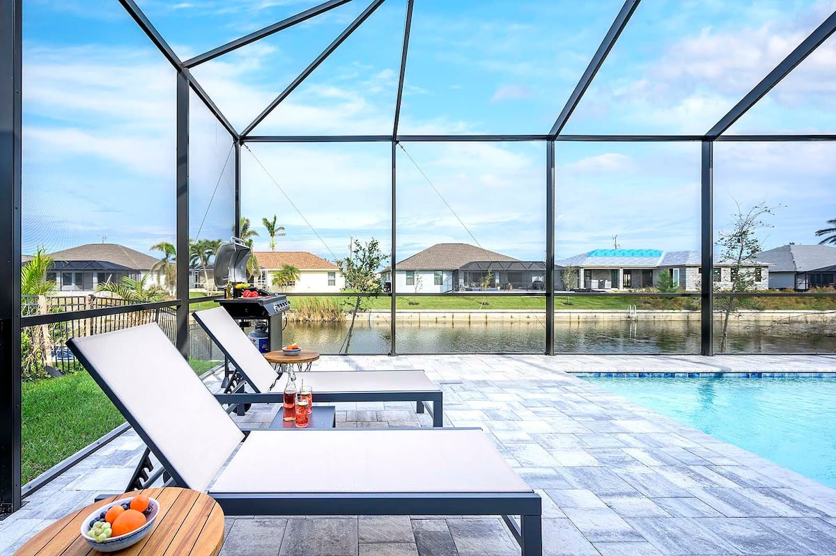 Privater Salzwasser-Pool mit Sonnenliegen und Blick auf den Kanal.