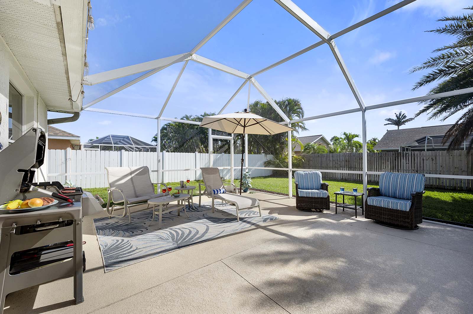 Privater Pool mit Sonnenliegen und Terrasse im eingezäunten Garten.