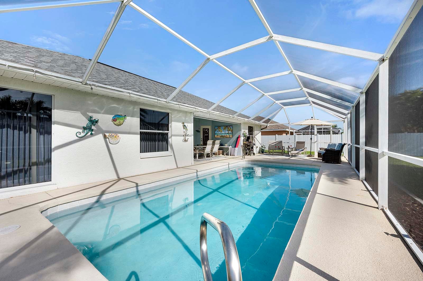 Privater Pool mit Sonnenliegen und eingezäuntem Garten.