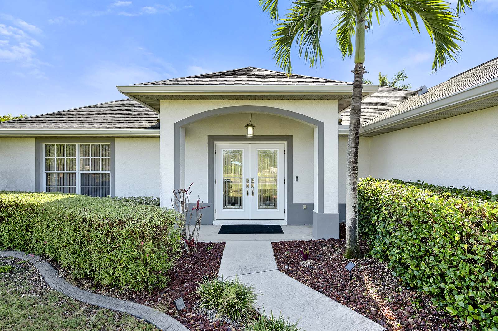 Privater Pool mit Sonnenliegen und Terrasse im eingezäunten Garten.