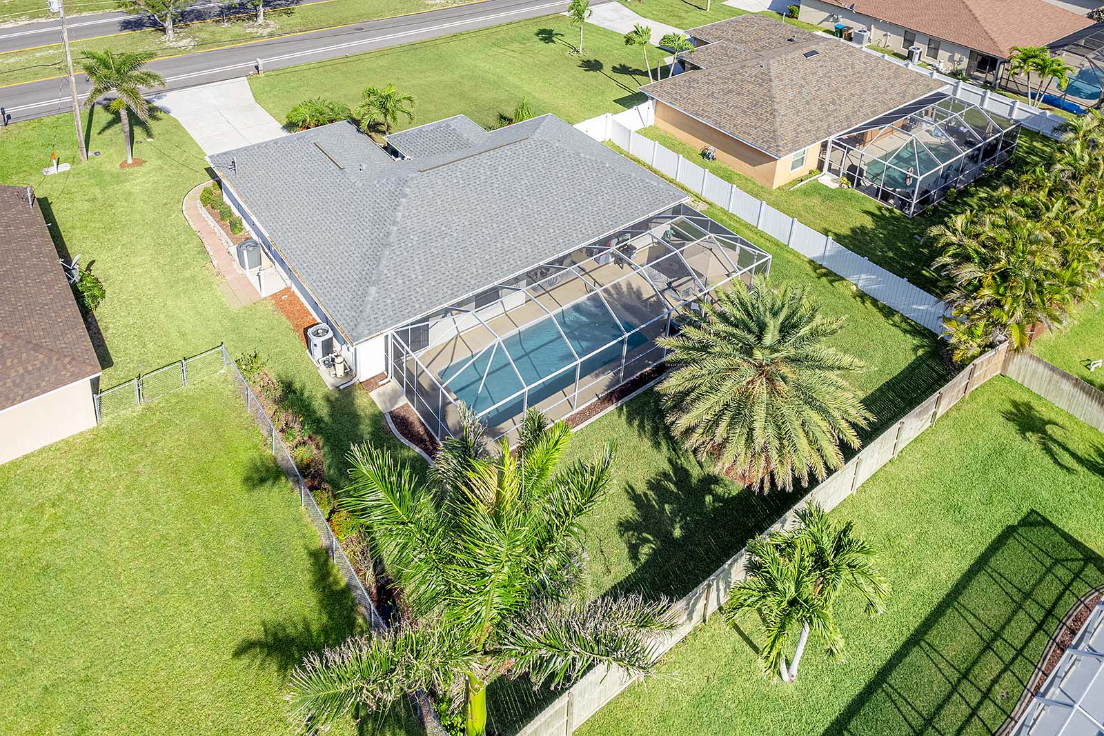 Privater Pool mit Sonnenliegen und Terrasse im eingezäunten Garten.