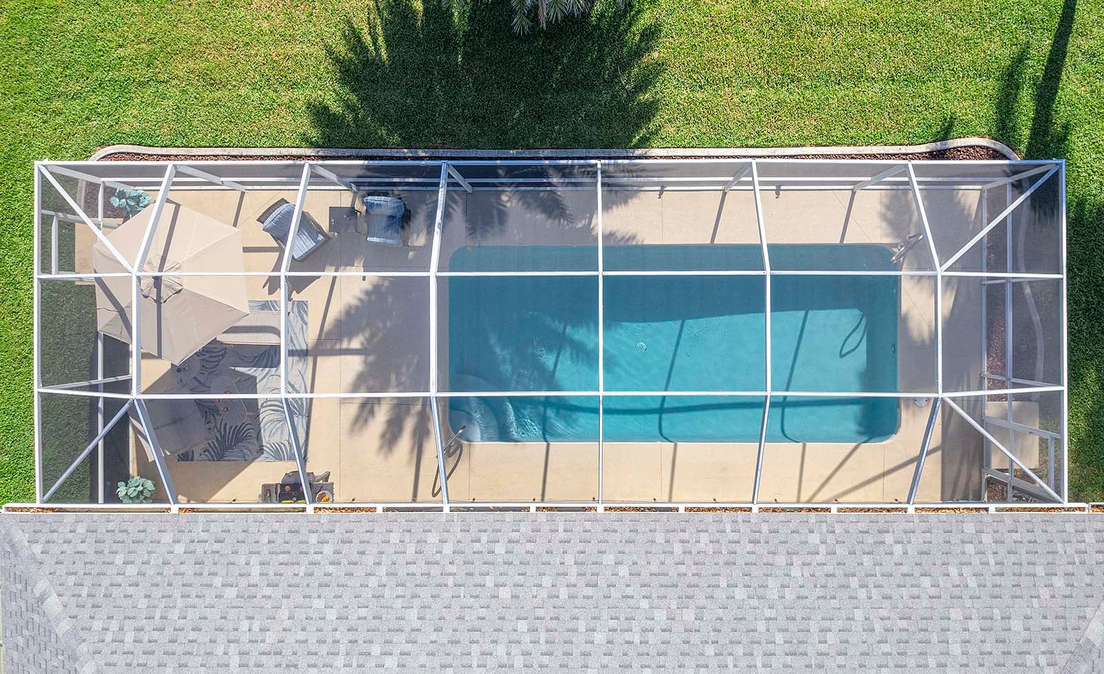 Privater Pool mit Sonnenliegen und eingezäuntem Gartenbereich.